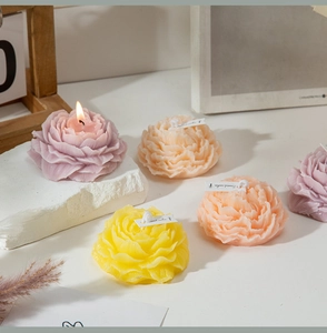 Dettaglio macro di candele profumate a forma di peonia nei colori viola, giallo e rosa