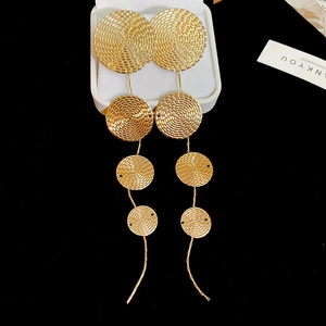 Detailed view of layered gold circular textured earrings on a jewelry display box