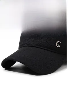 Detail of a black knit baseball cap featuring a silver C YM metal logo and reinforced brim