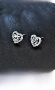 Macro view of s925 silver heart stud earrings with round moissanite center stone