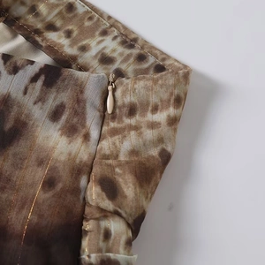 Detail of artistic leopard print fabric with gold lurex stripes and invisible zipper