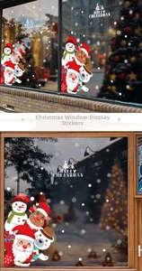 Detail of Christmas window clings featuring Santa, reindeer, and snowflakes on glass panels