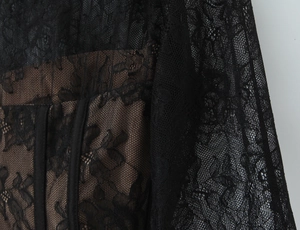 Detailed macro view of black floral lace and mesh texture with tan lining on a slim corset top