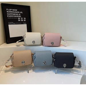 Close-up of mini crossbody bags with woven texture, metal locks, and geometric wide straps