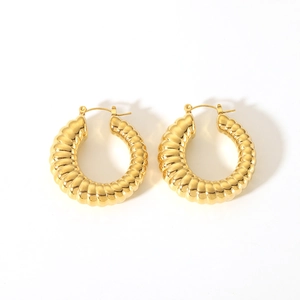 Détails macro de boucles d'oreilles créoles plaquées or 18K avec texture nervurée