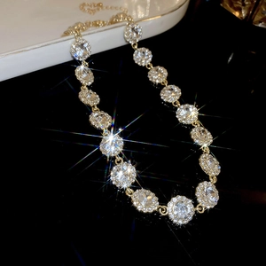 Détail d'un collier en zircon étincelant avec maillons dorés sur fond miroir noir