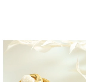 Close-up of a gold ring with an elegant white pearl center on a floral background