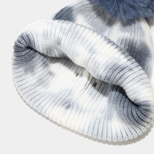 Dettaglio della spessa trama in maglia a coste e del motivo tie-dye sul cappello invernale