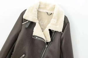 Detail showing faux leather texture and creamy faux shearling lining on biker jacket