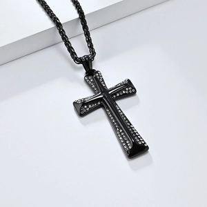Macro shot of black steel cross necklace with clear diamonds and woven rope chain