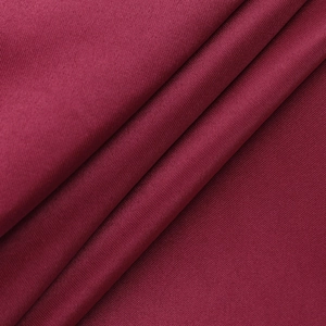 Vue macro d'un tissu bordeaux côtelé avec un drapé élégant sur une robe de soirée