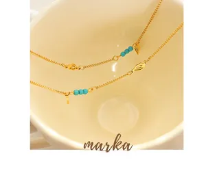 Macro shot of gold-plated titanium anklets featuring turquoise beads and wing charms