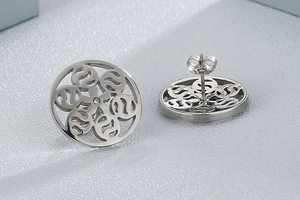 Macro view of silver hollow floral earrings with crystal centers and butterfly backs