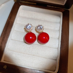 Detailed macro view of red bead flower stud earrings with sparkling clear crystals