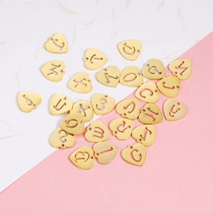 Golden 12mm stainless steel heart pendants with cutout A-Z letters on a split background