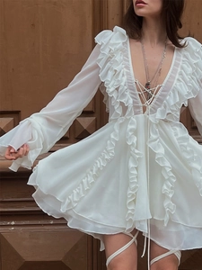 Detail of white chiffon mini dress featuring V-neck lace-up and elegant ruffle trimmings