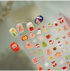 Macro view of Christmas nail art stickers featuring cartoon bears and festive patterns