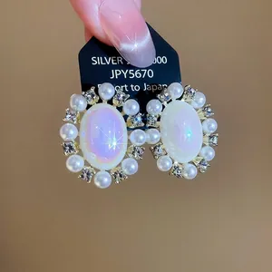 Elegant gold oval pearl earrings with sparkling zircons in a vintage floral sunburst design