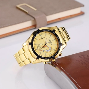 Close-up of gold multifunction chronograph watch with tachymeter bezel on white surface