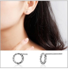 Macro detail of S999 sterling silver stud earrings with wavy hollow round design