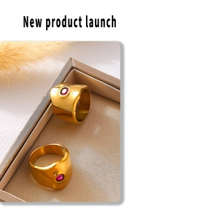 Detailed view of wide gold rings with red stones in an elegant jewelry box display