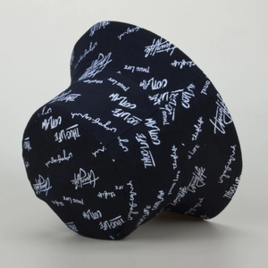 Close-up of black street style bucket hat with white Thug Life and Outlaw text
