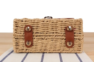 Detail of paper rope woven bag base with brown faux leather patches and silver rivets