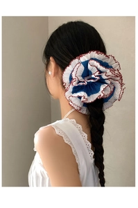 Lace ruffle hair scrunchie in blue with red trim on model's high ponytail