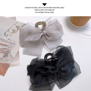 Large mesh bow hair claws in grey and black shown on a minimalist aesthetic background