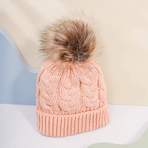 Detailed knit texture and fluffy faux fur pompom on this cozy pink winter cable hat