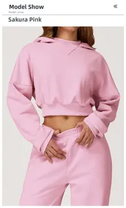 Detail of cherry pink hooded sweatshirt and high-waist joggers on a model in studio