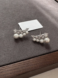 Macro view of silver studs featuring four gradient pearls with sparkling zircon accents