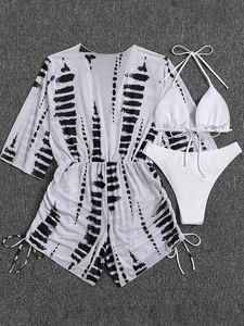 Detailed flat lay of a 3-piece white bikini set with black and white abstract print cover-up