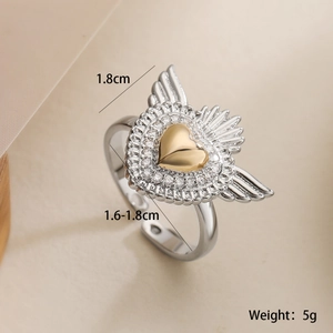 Macro shot of two-tone ring featuring a gold heart with zircon wings and light rays