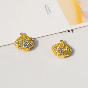 Macro detail of yellow shell charms with colorful rhinestones and gold alloy rings