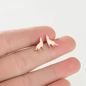 Detail shot of rose gold wolf silhouette earrings showing smooth polished finish