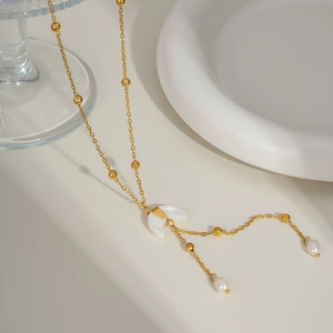 Detail of gold moon pendant with white mother of pearl and small pearl accents