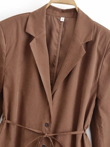 Detail of a brown mid-length belted blazer with collar size S label and smooth fabric texture