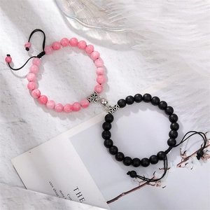 Detail of magnetic heart clasp connecting pink marble and black matte beaded bracelets