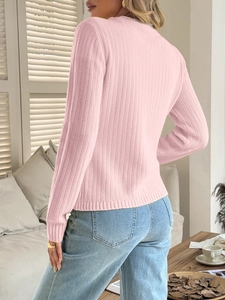 Rear view of pink knitted sweater with long sleeves in a soft domestic light setting