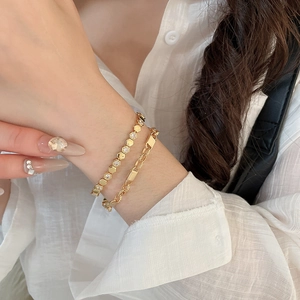 Detailed macro view of 18k gold plated honeycomb bangle and geometric link bracelet