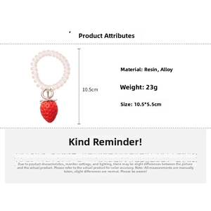 Détail macro d'un élastique spirale transparent avec un pendentif fraise réaliste en résine