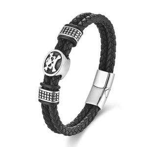 Close-up of black braided leather bracelet with silver skull charm and magnetic clasp