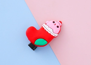 Détail d'une pince à cheveux chaussette de Noël en caoutchouc sur un fond coloré pastel