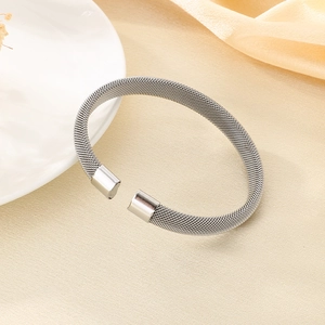 Dettaglio del bracciale rigido aperto a rete argentata con estremità in metallo solido
