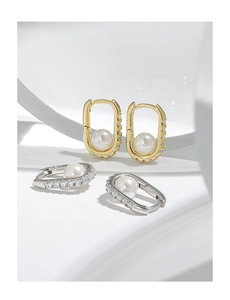 Macro detail of U-shaped S925 silver earrings with pearls and zircon in gold and silver