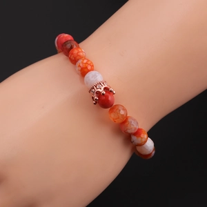 Detailed close-up of 8mm faceted agate beads with a rose gold crown charm on a bracelet