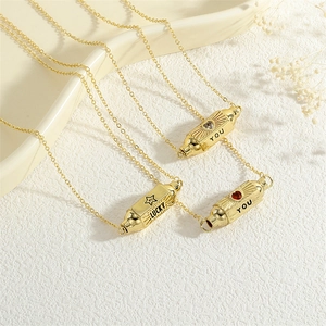 Close-up of gold hexagonal cylinder pendants with Lucky and You engravings and zircon