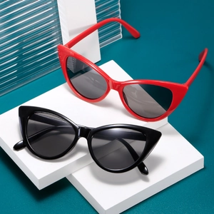 Fashionable cat eye sunglasses in red and black displayed on modern white geometric stands