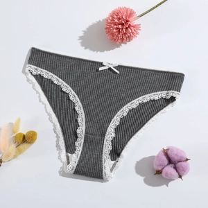 Dark grey ribbed cotton briefs for women with white lace trim and bow on a cozy background
